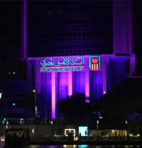 لأول مرة في تاريخه.. البنك الأهلي المصري يُضيء مبناه باللون الوردي .. صور